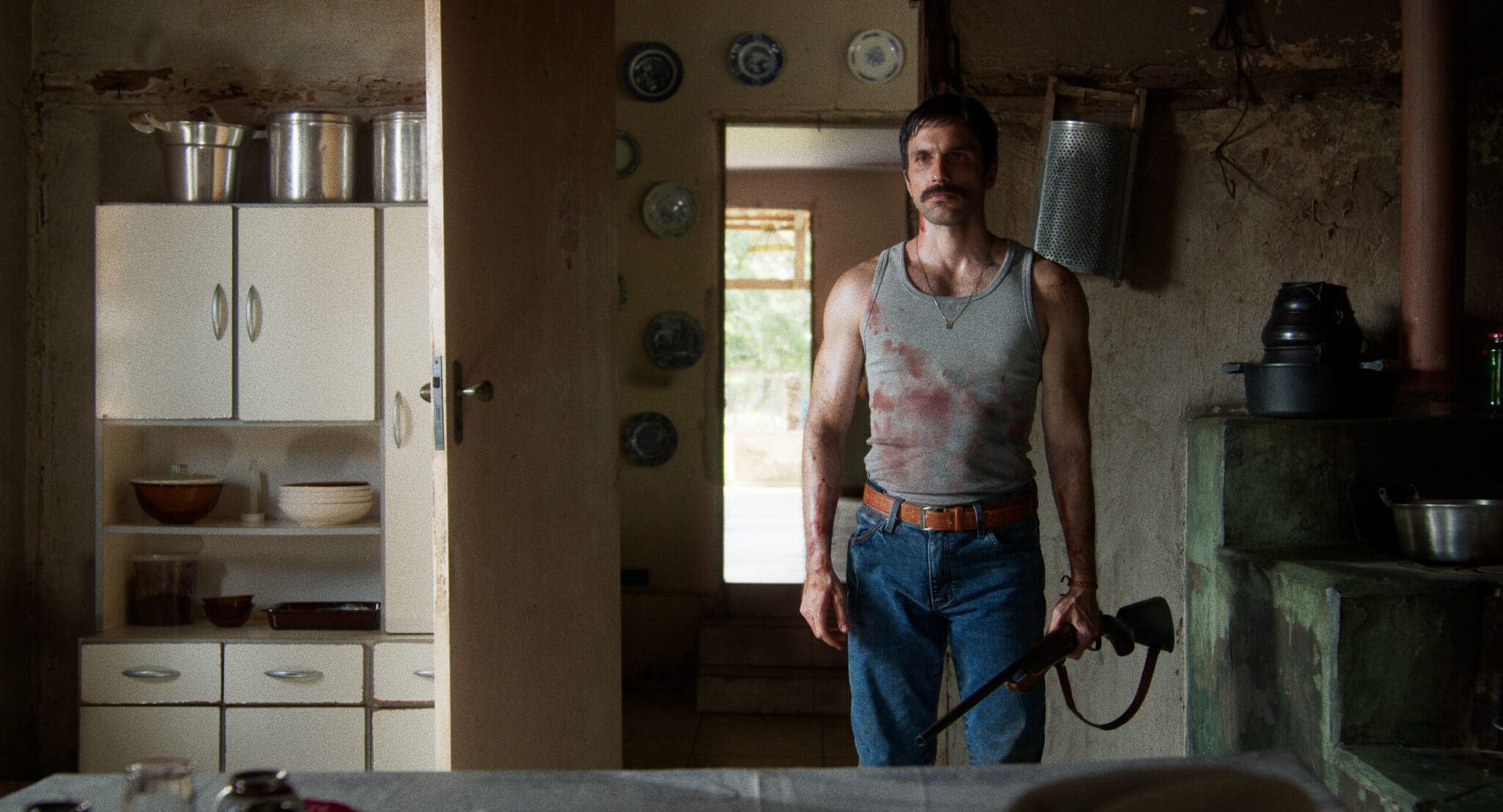 Antonio holding a rifle indoors in Only Good Things